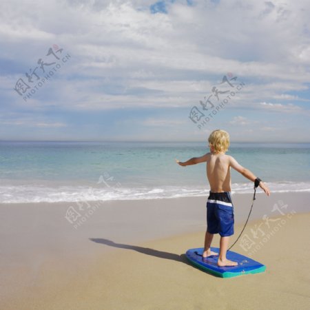 海滩沙滩玩滑板的小帅哥图片