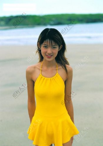 穿黄衣的少女在海滩边图片