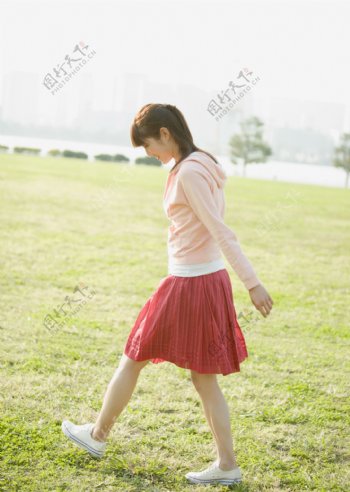 草地上走路的女孩图片