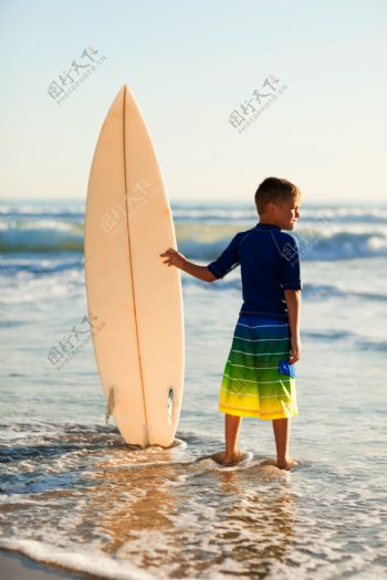 扶着冲浪板的男孩图片