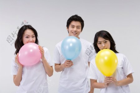 三个拿着彩色气球活力青年图片