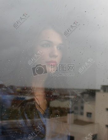 前拖女人窗口的玻璃在城镇在展望
