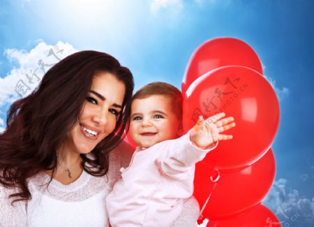 抱着小孩的母亲和气球图片