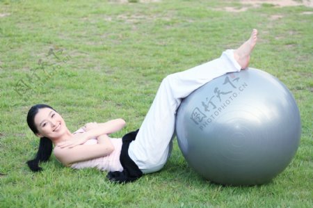 躺在草地上做运动的瑜伽少女图片图片