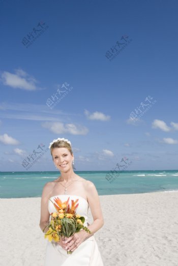 沙滩上拿着捧花的新娘图片