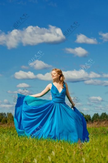 草地上的蓝裙美女图片
