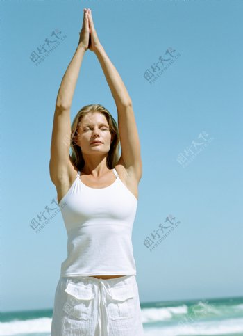 海边练瑜珈的健康女性图片