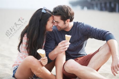 沙滩上吃甜筒的情侣图片