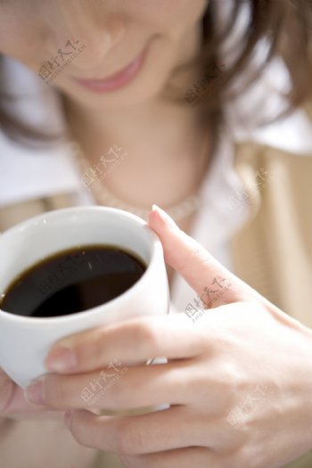 手捧咖啡的女性图片
