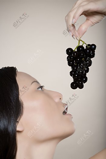 品尝美味葡萄的美女图片