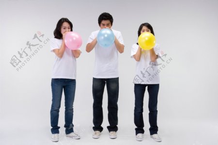 三个活力男女一起吹气球图片