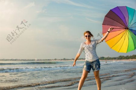 海滩打伞的时尚女性图片