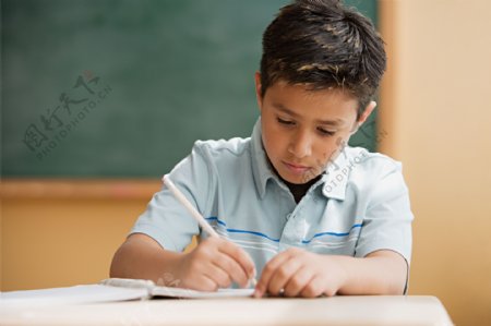 教室里写作业的外国男孩图片