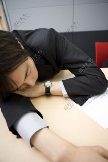 趴在办公桌上睡觉的商务男性图片