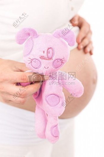 怀孕的女性拿着娃娃