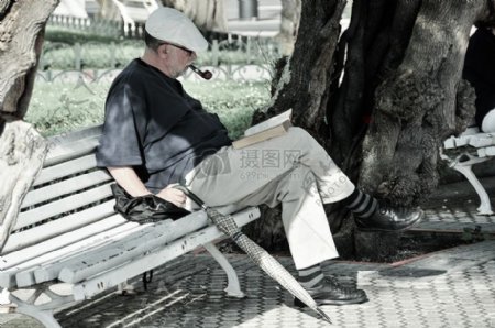 长椅上阅读的男子