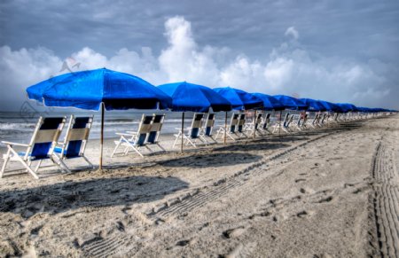 沙滩上的太阳伞雨伞蓝色的海滩太阳伞图片