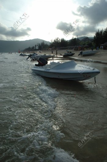 海滩落日下的摩托艇图片