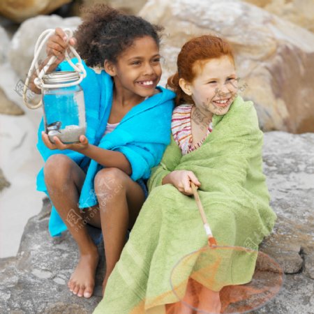 沙滩岩石上快乐的小女孩图片