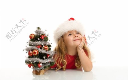 趴着手拿圣诞树带着圣诞帽的小女孩图片