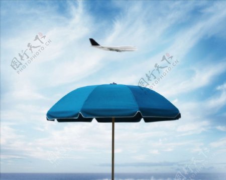 飞机飞越海滩伞图片