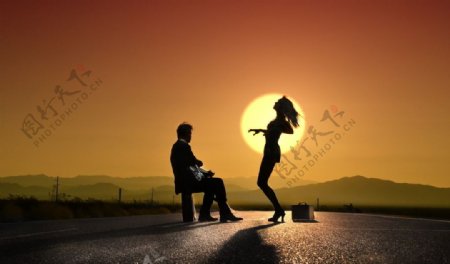 夕阳下歌舞的情侣图片