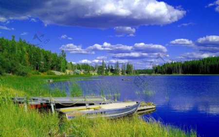 蓝天下的湖畔小船图片