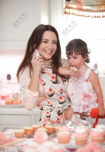 美女妈妈抱着孩子在蛋糕店购物图片