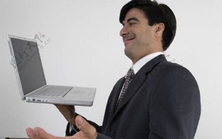 拿着笔记本电脑苦笑的商务人物图片
