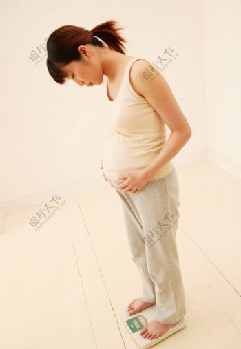 怀孕称重量的女人图片