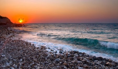 夕阳海浪海滩鹅卵石图片