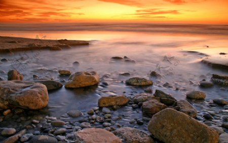 海边石滩的日落景色图片