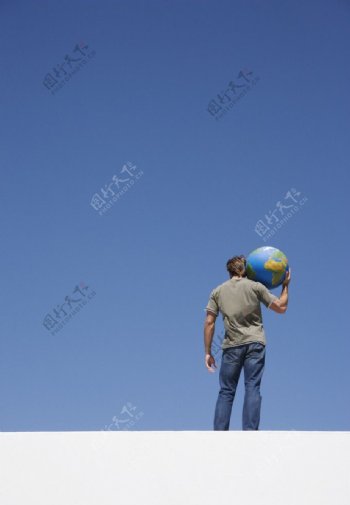 扛着地球模型的男人图片