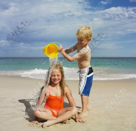 海滩沙滩浇水的小姐弟图片