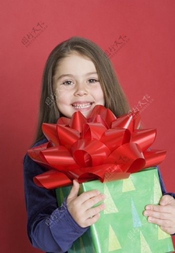 抱着礼品盒的微笑小女孩图片