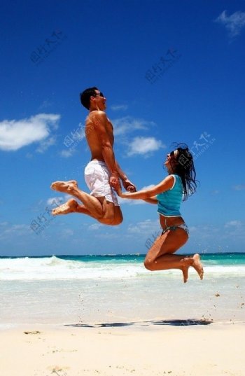 沙滩上跳跃情侣
