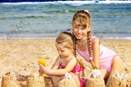 沙滩上玩沙的两个小女孩图片