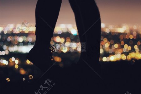 七夕城市夜景下踮起脚尖接吻的情侣