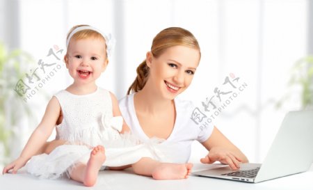 坐在电脑前微笑的母女图片