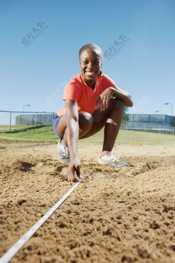 测量沙坑的女性运动员图片