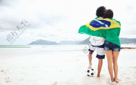 沙滩上披着世界杯旗帜的情侣图片