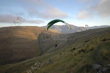 在高山上玩滑翔伞的人