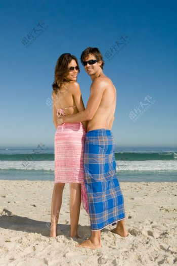 沙滩上的站着的情侣图片