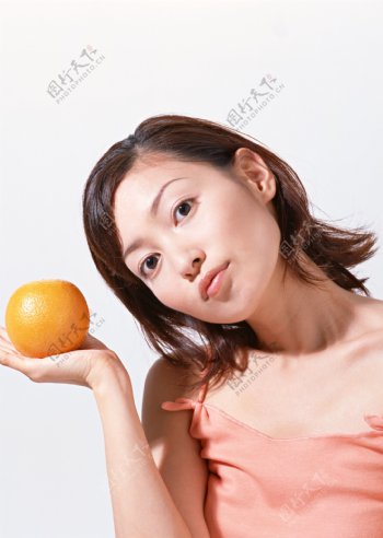 手拿橙子的时尚美女图片