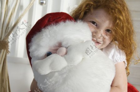 抱着圣诞老人玩具的小女孩图片