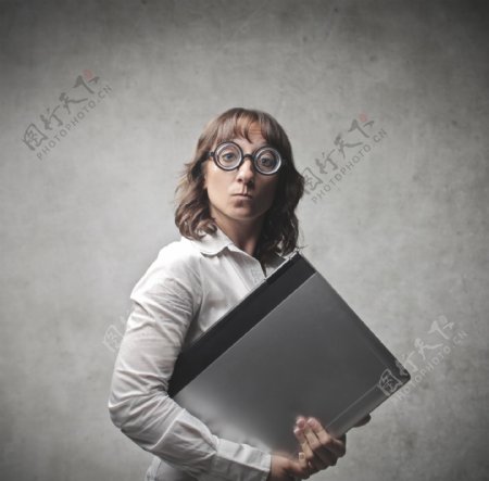 瞪着眼睛抱电脑的职业女性图片