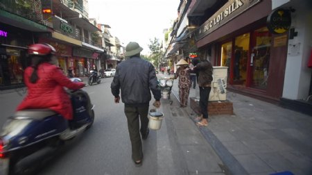 在越南街上用水桶走路的男人