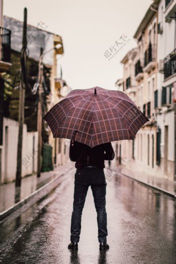 男人雨中撑伞背影